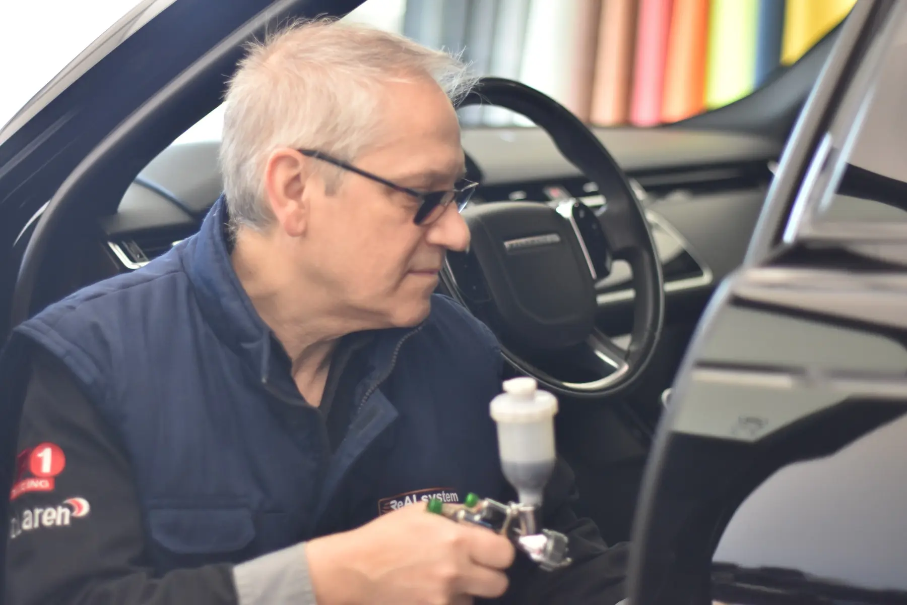 Enrico Lanciani durante l’applicazione professionale con aerografo su un componente interno auto
